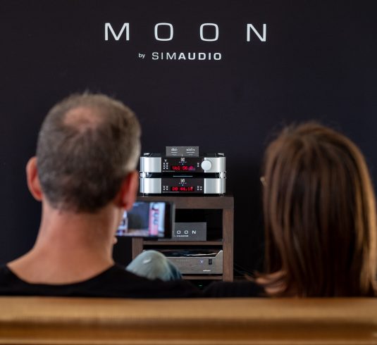 couple assis devant un système son moon